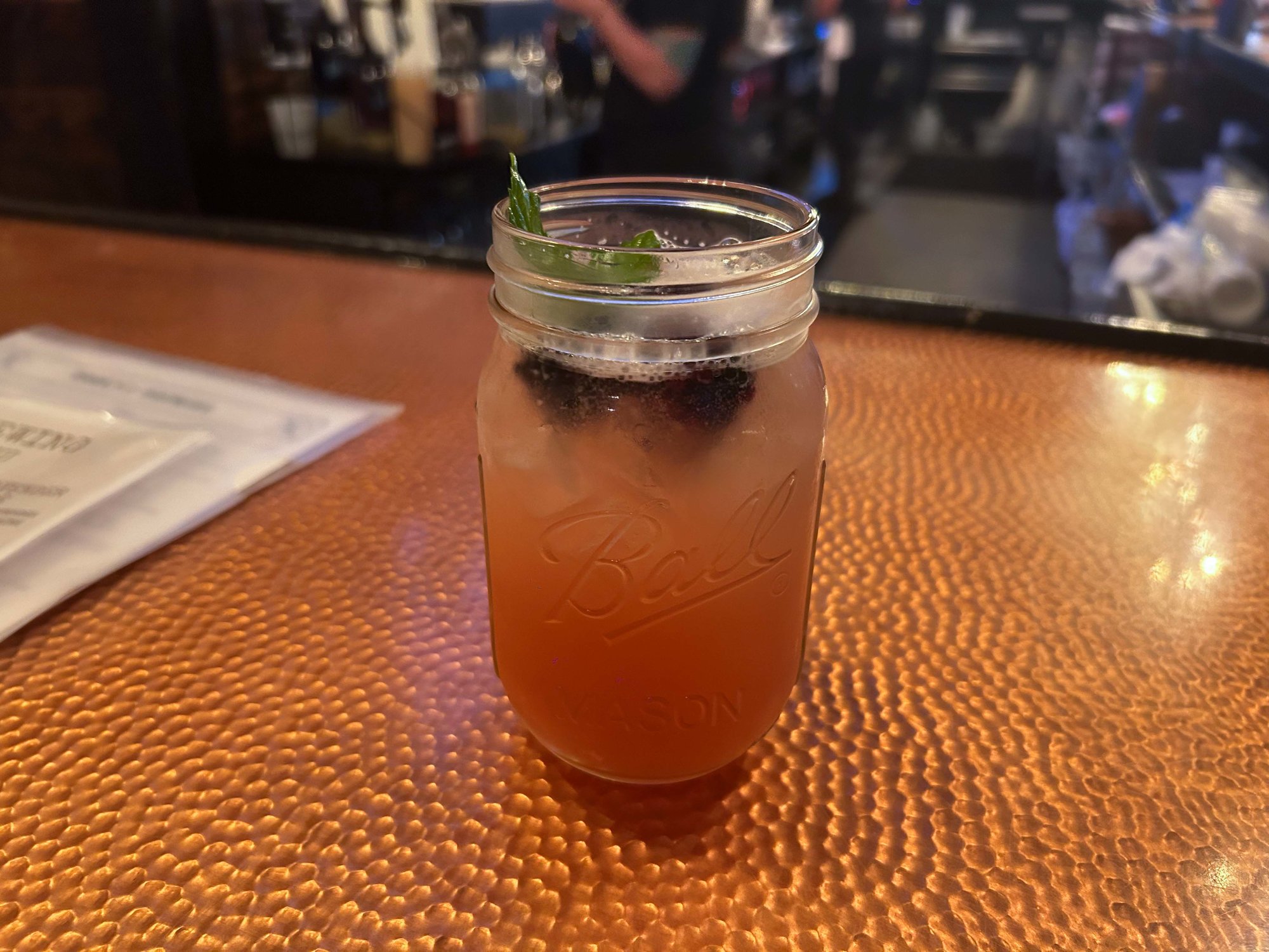 fruity cocktail drink in a mason jar on the bar counter